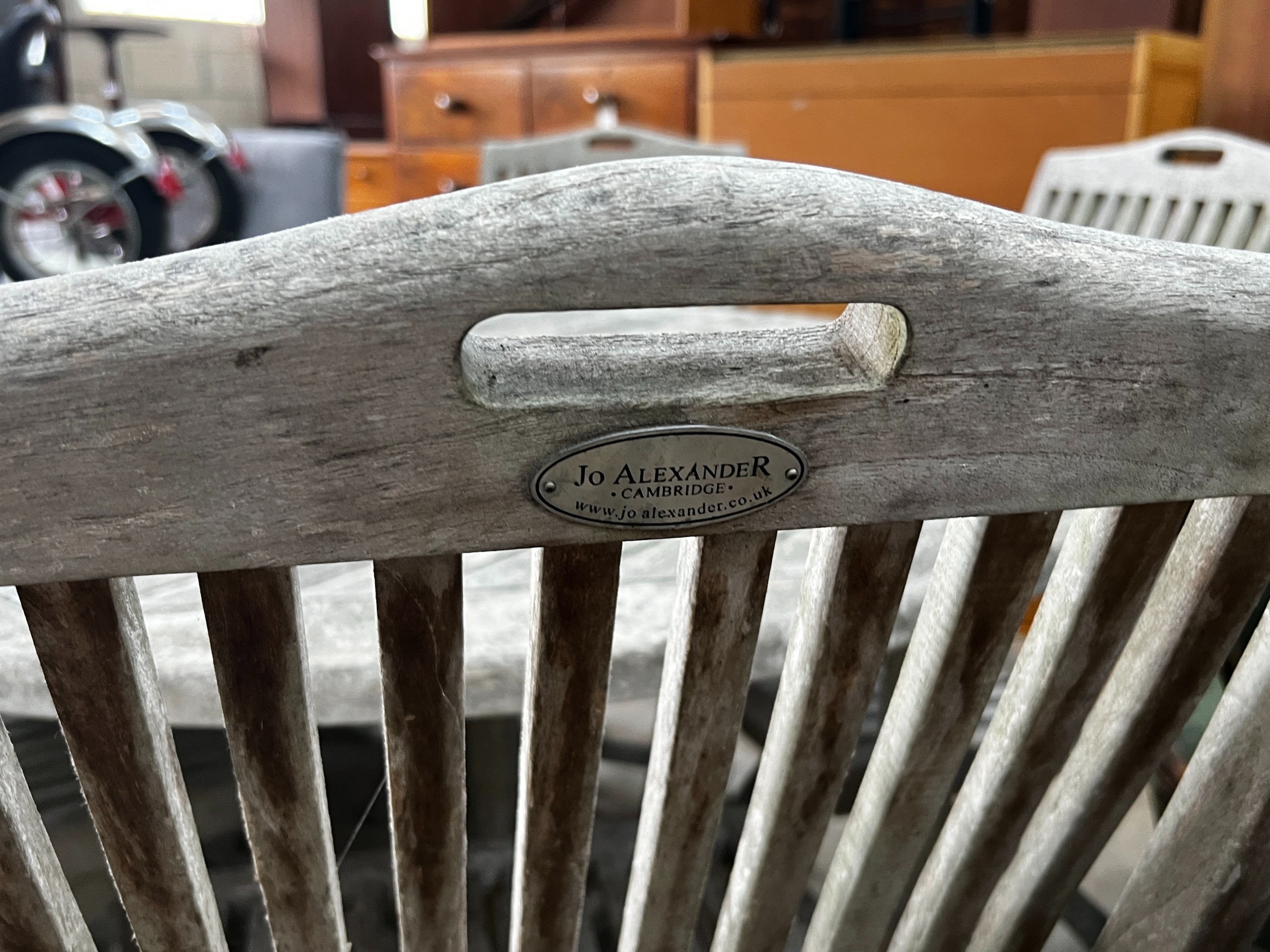 A Jo Alexander circular weathered teak folding garden table, diameter 120cm, height 75cm and four chairs *Please note the sale commences at 9am.